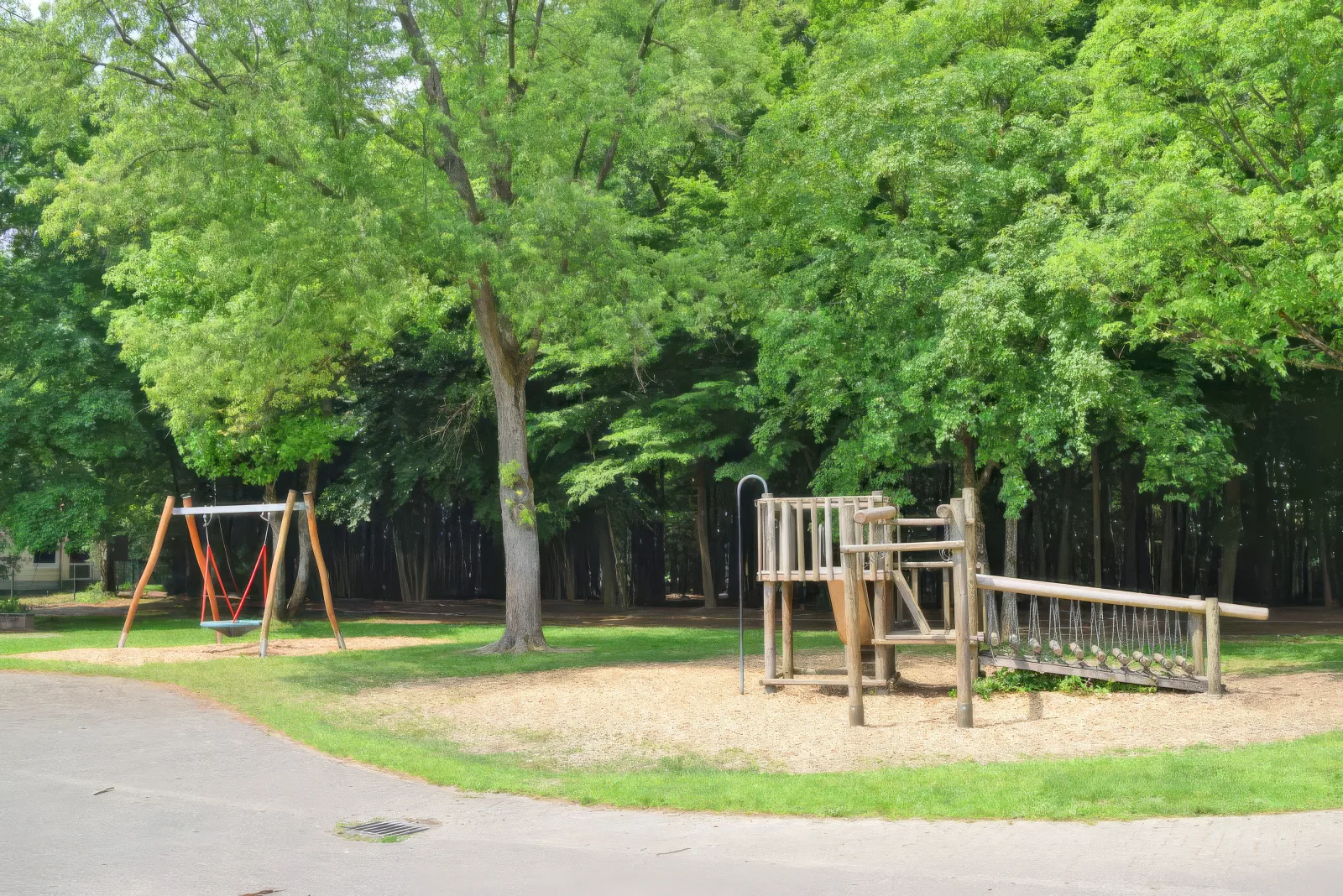 Weitläufiges grünes Außengelände der GGS Auf dem Höchsten mit Spielflächen und Wald
